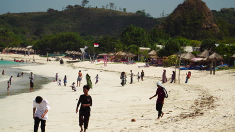 Sandy-exotic-beach-with-people-in-Lombok-Island,-handheld