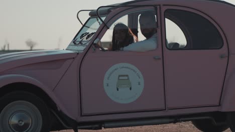 In-Einem-Rosafarbenen-Auto-Sitzen-Ein-Mann-Und-Eine-Frau-Und-Genießen-Die-Gesellschaft-Des-Anderen