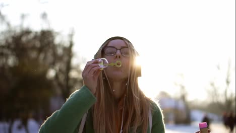 Young-Woman-inflates-soap-bubbles-in-the-winter-during-the-cold-weather