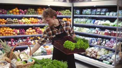 Salad-bar-with-organic-vegetables-and-greens-in-supermarket.-Male-shop-employee-arranging-fresh-greens-on-a-bar-in-local-supermarket