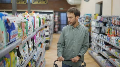 Man-walks-through-the-supermarket-and-takes-goods-from-the-shelf