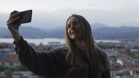 Long-haired-woman-takes-a-photo-with-a-smartphone-in-her-hands