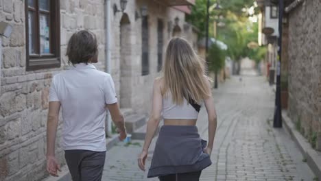 Young-traveler-couple-walking-narrow-streets-in-historical-old-town