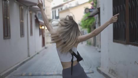 Blonde-woman-dance-outdoors,-spinning-around,-emotional