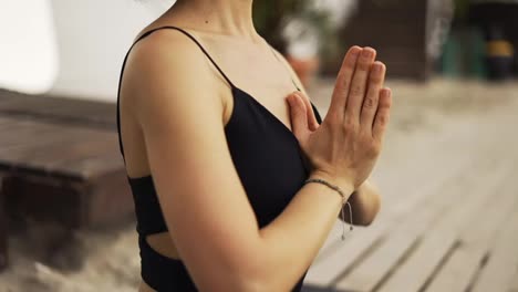 Ausgeschnittene-Ansicht-Weiblicher-Hände-Bei-Der-Meditation-Am-Strand