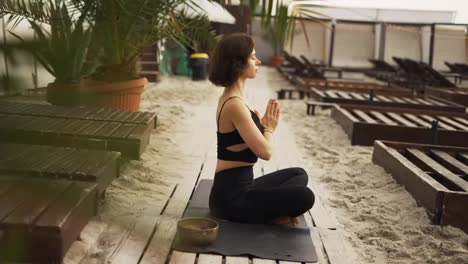 Frau-Sitzt-In-Meditation-Am-Strand
