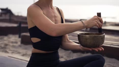Unrecognizable-woman-with-tibetan-singing-bowl-for-yoga-and-meditation,-slowmo