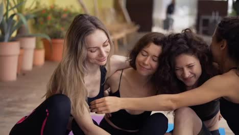 Happy-yoga-group-hugging-and-smiling-after-workout-on-the-terrace,-close-up