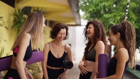 Fitness,-sport-and-healthy-lifestyle-concept---group-of-women-with-mats-at-yoga-studio-outdoors