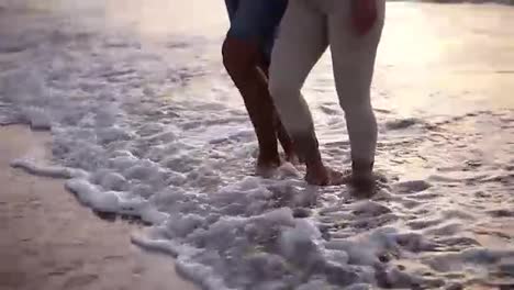 Close-up-view-video-of-man-and-woman-walking-bare-feet-at-sandy-beach-by-ocean.-Happy-couple-enjoying-summer-vacations-at-hot