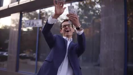 Caucasian-businessman-in-blue-suit-throw-handful-of-banknotes-in-the-air.-Super-excited-businessmen-in-glasses-throw-cash-in