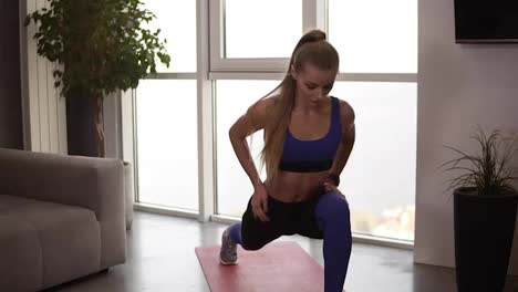 Young-fit-female-in-sportswear-doing-stretching-lunge-exercise-indoor,-home-interior.-Activity-and-healthy-lifestyle.-Front-view