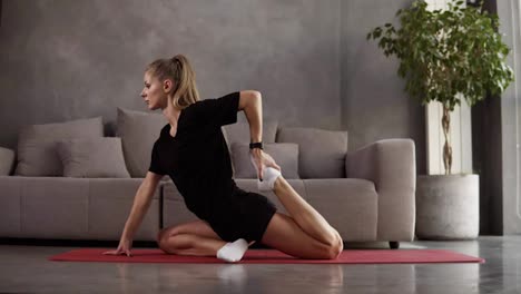Flexible-woman-practice-yoga-postures-and-doing-stretching-in-loft-interior-room,-slim-girl-doing-stretching-exercise-on-mat.-Female-pilates-body-care-concept.-Healthy-and-sport-lifestyle