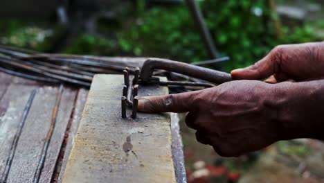 carpenter-in-india-black-male-skilled-hands-close-up-bending-construction-iron-steel-Rond-manually