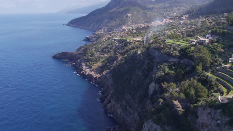 Reveal-shot-of-Torre-del-Verger-and-coast-of-Banyalbufar-Touristic-Town-in-Mallorca,-aerial