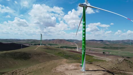 Grüne-Windkraftanlage-Steht-Auf-Einer-Wiese-Mit-Anderen-Windmühlen