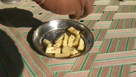 close-up-scene-where-fresh-Cassava-wafers-are-being-topped-with-pepper-masala-which-is-very-tasty-to-eat
