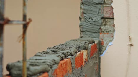 wall-building-in-construction-site-close-up-putting-cement-on-bricks-wall