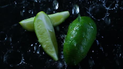 Water-drops-fall-on-slices-of-lime-on-a-black-wet-surface