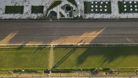 Horses-racing-on-the-race-track-during-sunset,-aerial-overhead