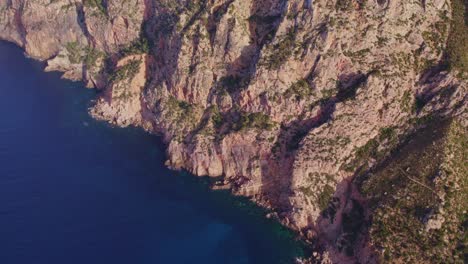 Tilt-up-shot-of-rocky-coastline-at-Mallorca,-Balearic-Islands,-Spain