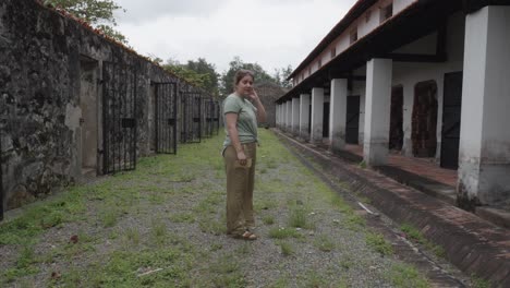 Erwachsene-Frau-Steht-Vor-Alten,-Verlassenen-Gefängniszellen-Von-Con-Dao-In-Vietnam
