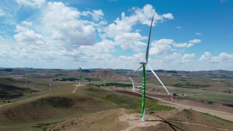 Green-wind-turbine-standing-on-a-meadow-with-other-windmills