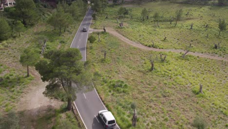 Car-is-driving-on-small-road-at-Mallorca-Island-Spain-during-day,-aerial