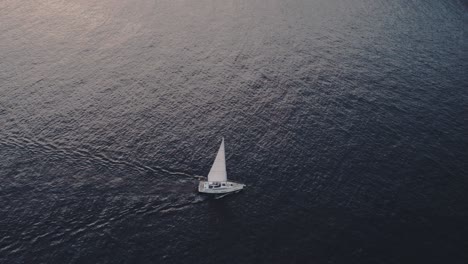 Tilt-down-shot-of-sail-boat-cruising-on-calm-ocean-at-Mallorca-island,-aerial