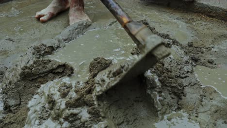 cement-mixing-in-remote-indian-village-construction-site-barefoot-labor-close-up-poor-unsafe-working-condition-concept
