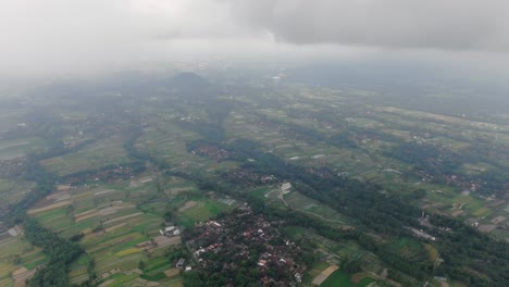Heavy-fog-over-landscape-of-Indonesia,-high-altitude-drone-view