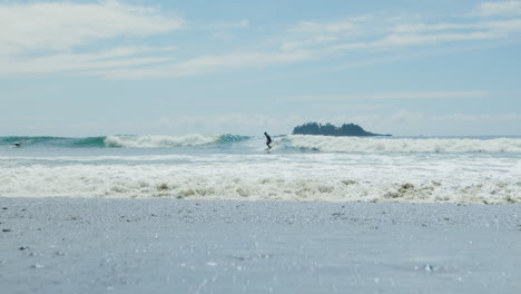 Slow-Motion-Tracking-Shot-of-Distant-Surfer-Surfing-Shimmering-Waves