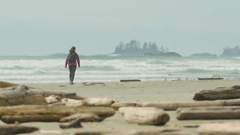 Woman-walking-alone-on-Long-Beach,-Pacific-Rim,-Canada