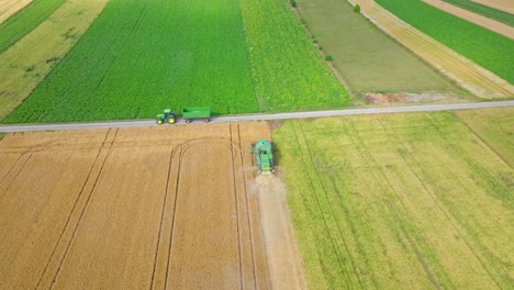 Aerial-View-Of-Harvesting-Machine-Working-In-The-Field---drone-shot