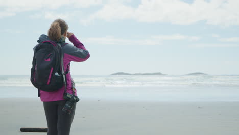 Outdoor-Active-Woman-with-DSLR-Camera-on-Beach-Enjoys-Ocean-View-REAR
