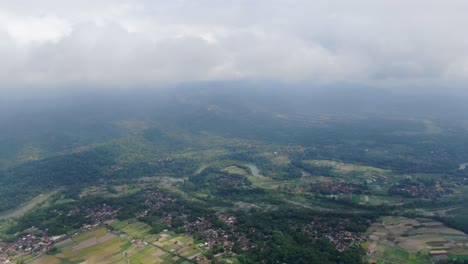 Countryside-life-of-Indonesia-village-near-foggy-mountains,-aerial-drone-view