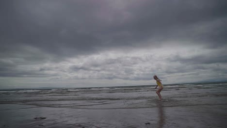 Teenager-captured-in-slow-motion-running-towards-the-sea-and-turning-back