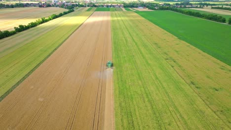Harvester-Machine-In-The-Wheat-Field-At-Daytime---aerial-drone-shot