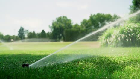 Nahaufnahme-Einer-Sprinkleranlage,-Die-Tagsüber-Einen-Grünen-Rasen-Bewässert