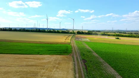 Agricultural-Fields-And-Wind-Turbines-In-Summer---aerial-drone-shot