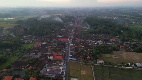 evening-time-aerial-view-of-a-road-crossing-the-city-of-Ubud-with-many-houses-and-rice-plantations-surrounding---Bali,-Indonesia