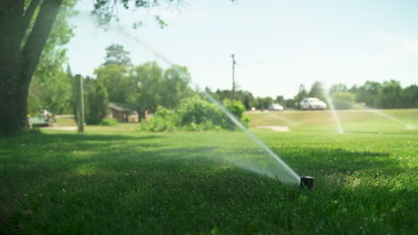 Sonniger-Tag-Sprinkler-Bewässert-Gras-Im-öffentlichen-Park-Im-Freien