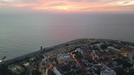 Aerial-Sunset-Drone-Above-Cartagena-Sea-Colombia,-Historic-Cathedral-Coastline-and-Cityscape,-Travel-Destination-in-Latin-America