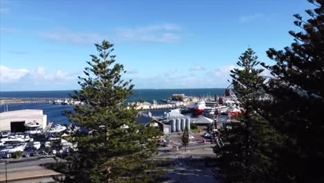 Aerial-View-Flying-above-trees-in-Fremantle-shot-of-Ferris-Wheel-in-Western-Australia-with-harbour