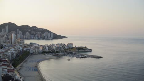 Mediterranean-dawn,-wide-view-Benidorm-beach-and-coastline-from-above-4K