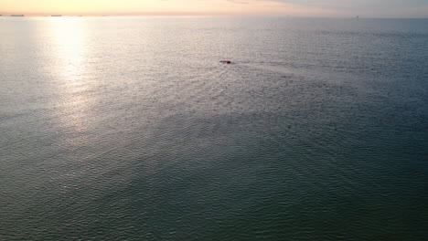 Lone-Man-Swimming-in-a-Sea-At-Early-Morning-Sunrise---Aerial-HIgh-Up