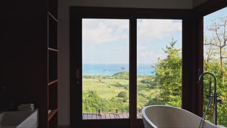 High-end-bathroom-with-luxury-furnishings-overlooking-mountains-and-ocean-outside