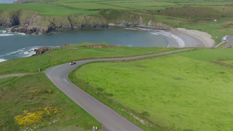 dramatic-view-of-Kilmurrin-Cove-Copper-Coast-Waterford-Ireland-with-a-classic-Car-on-a-rally-early-summer
