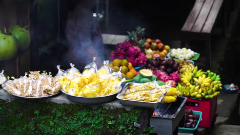 A-local-street-stall-selling-BBQ-grilled-foods-and-fresh-fruit-on-the-island-of-Bali,-Indonesia