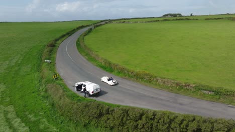 Classic-car-climbing-a-hill-on-The-Copper-Coast-Waterford-Ireland-on-a-summer-morning